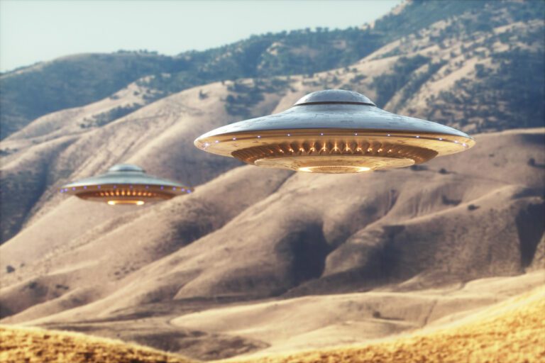 Two flying objects shaped like saucers hover over a desert landscape