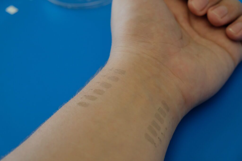 A wrist is extended, showing two rows of six light gray parallel lines