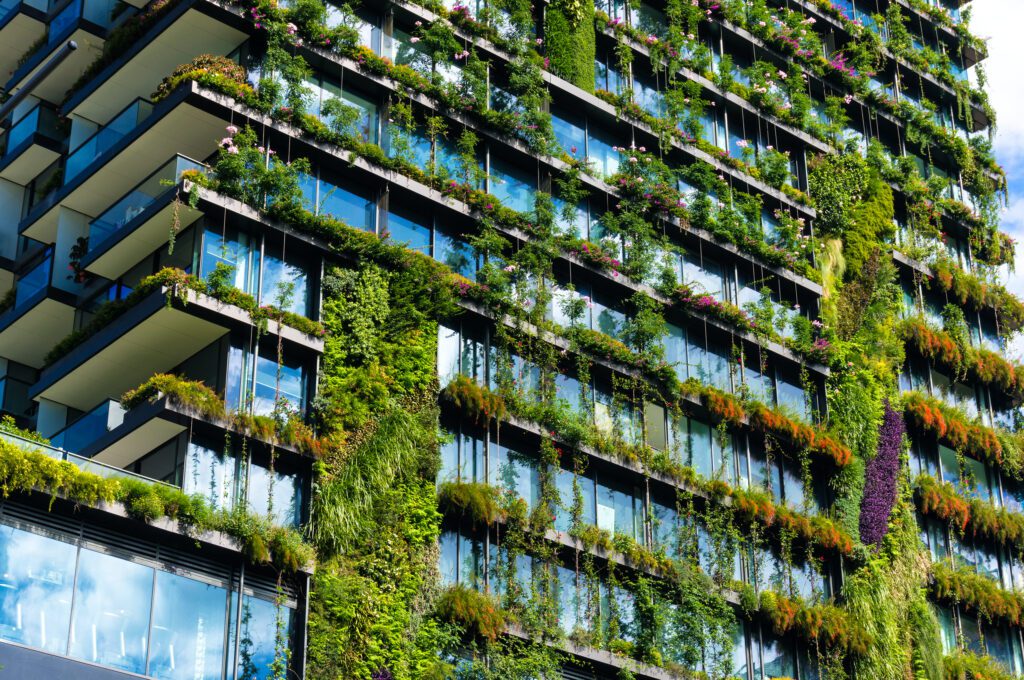 Greenery covers the glass windows of a skyscraper
