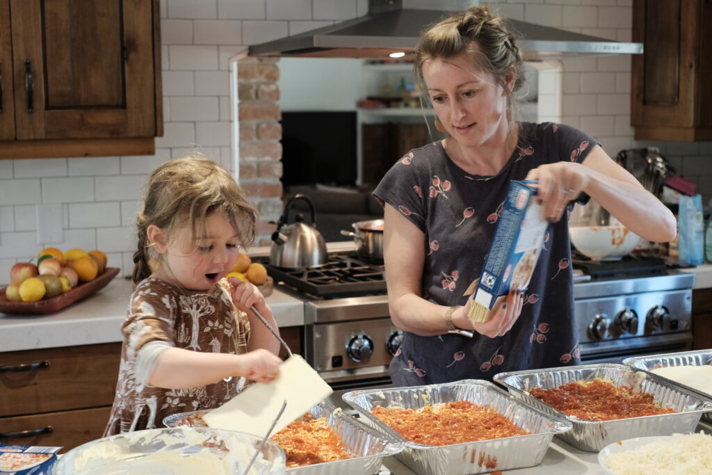 Nonprofit Lasagna Love founder Rhiannon Menn making lasagnas in her kitchen with her daughter