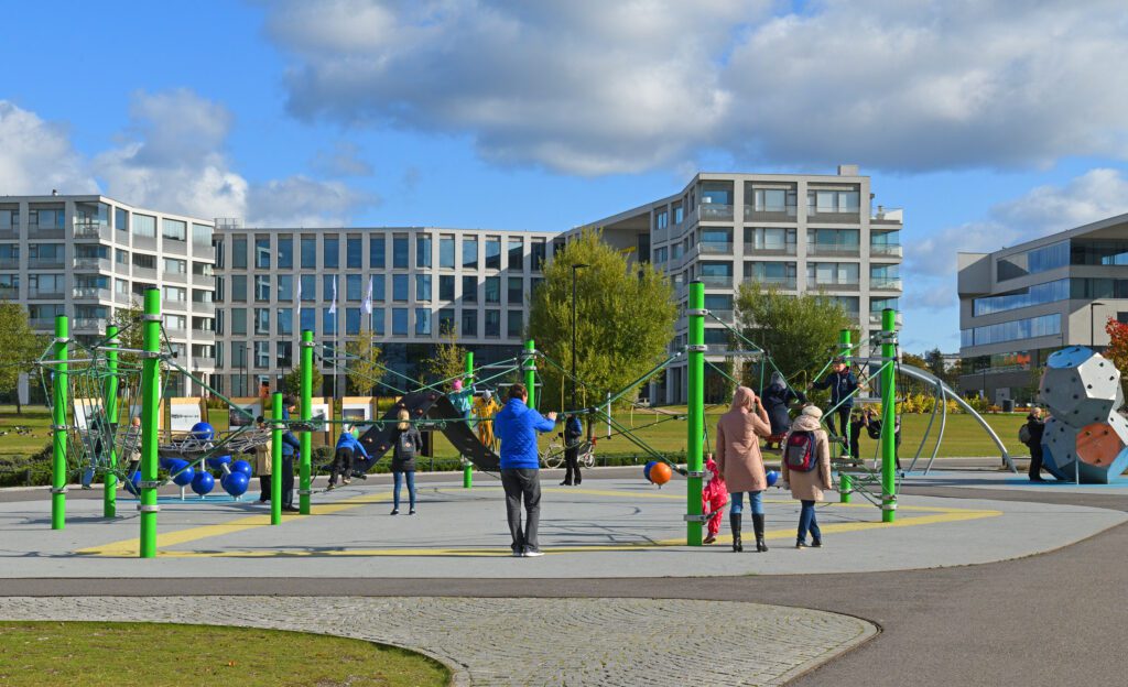 Kids and parents on a playground under a blue sky in Helsinki