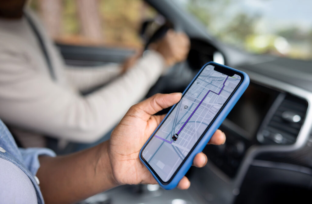 Close-up on an African American couple using the GPS on a cell phone while driving a car.