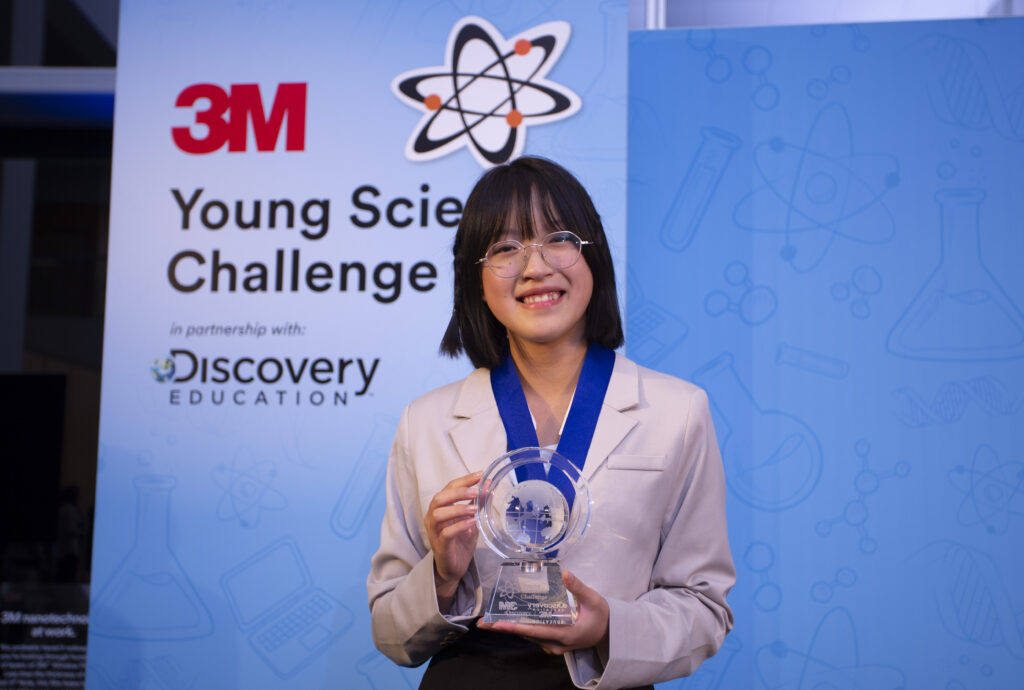 Leanne Fan stands smiling with her Top Young Scientist award