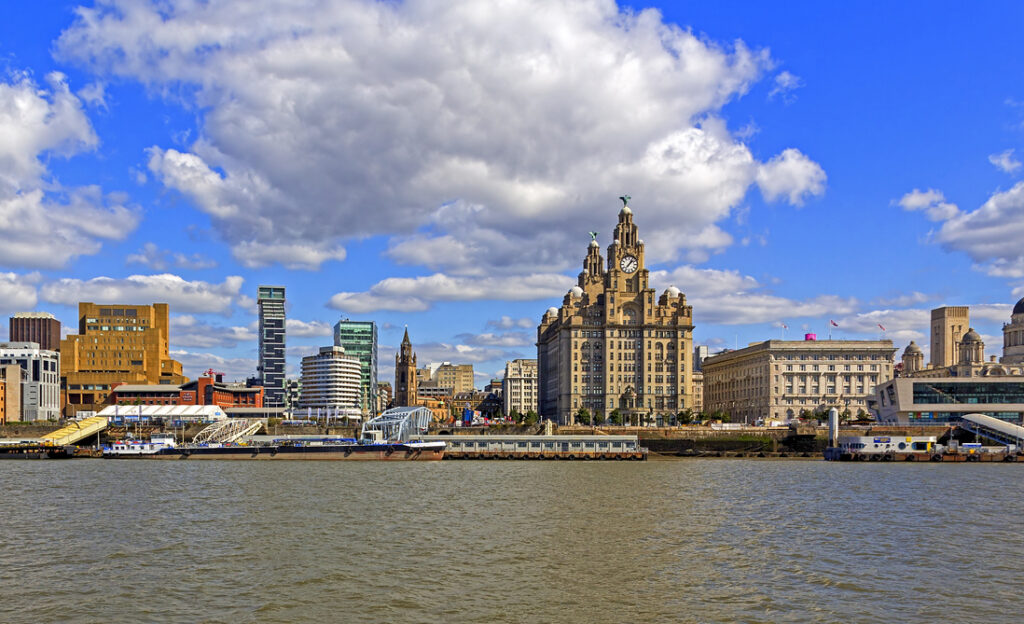 a view of the river mersey with a city skyline on a clear day