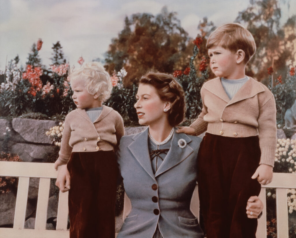 September 1952: Queen Elizabeth II with Prince Charles and Princess Anne in the grounds of Balmoral Castle, Scotland. Charles is celebrating his 4th birthday.