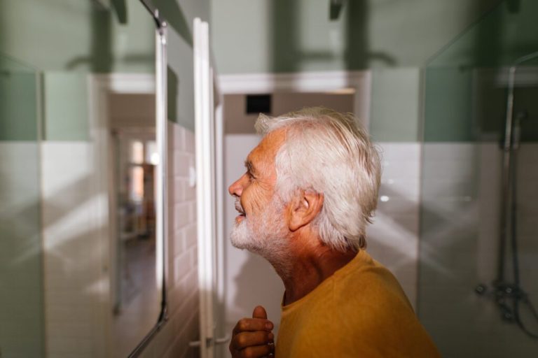 SENIOR MAN IN BATHROOM, PERFORMING HIS MORNING ROUTINE (ALEKSANDARNAKIC / E+ VIA GETTY IMAGES)