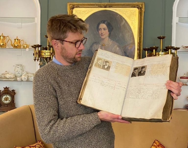 Jim Spencer holds the book of Victorian mugshots