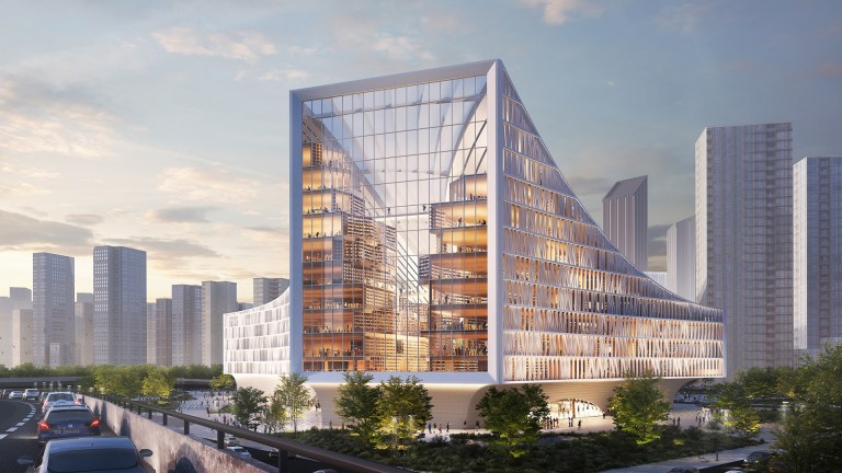 an exterior view of the new library in Wuhan, featuring a facade full of windows and sloping sides. Inside you can see the tall shelves of books forming a canyon for guests to walk through.