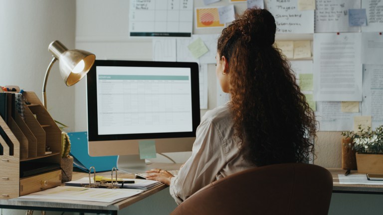 Shot of an unrecognisable businesswoman sitting alone and using her computer while working from home