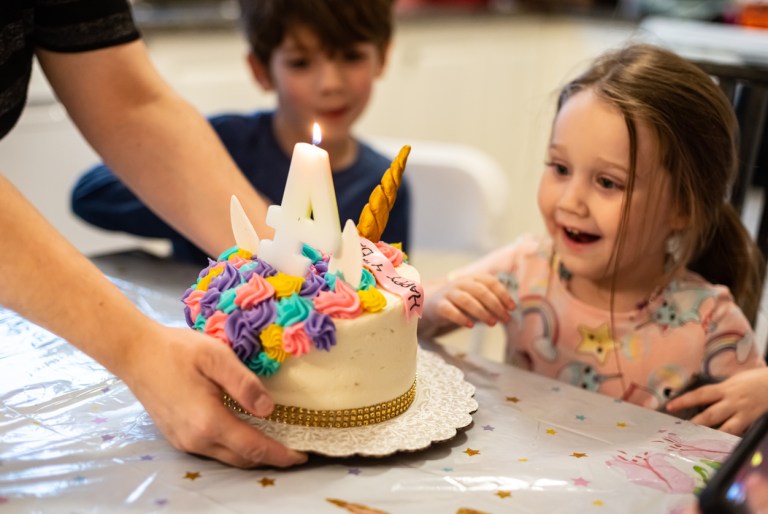 A girl is excited for her birthday cake.