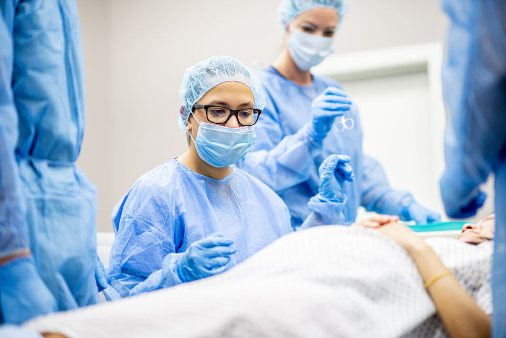 Team of doctors and nurses wear masks and gloves and prepare for surgery.